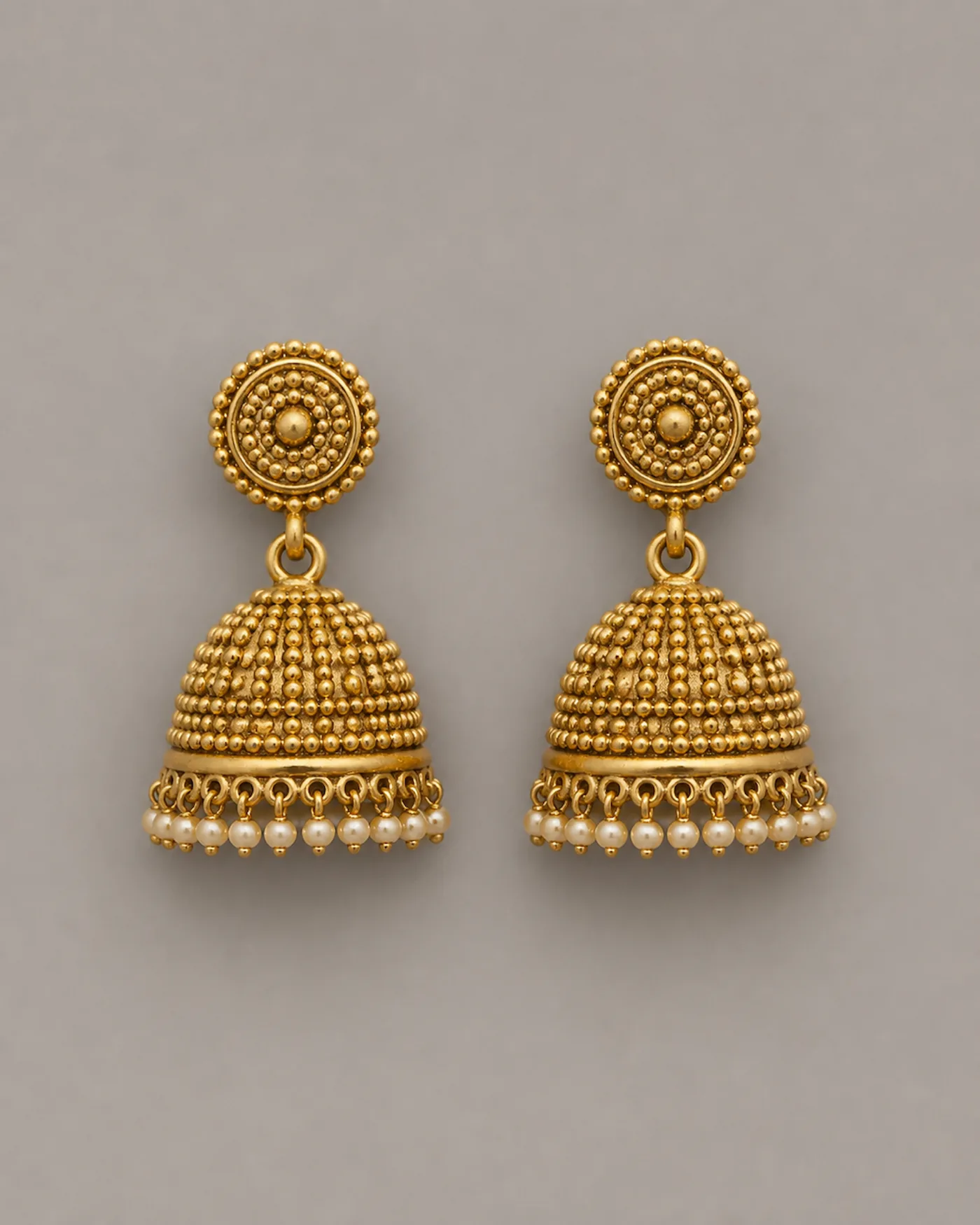 Pair of small gold jhumka earrings, each a granulated dome hung with a fringe of seed pearls