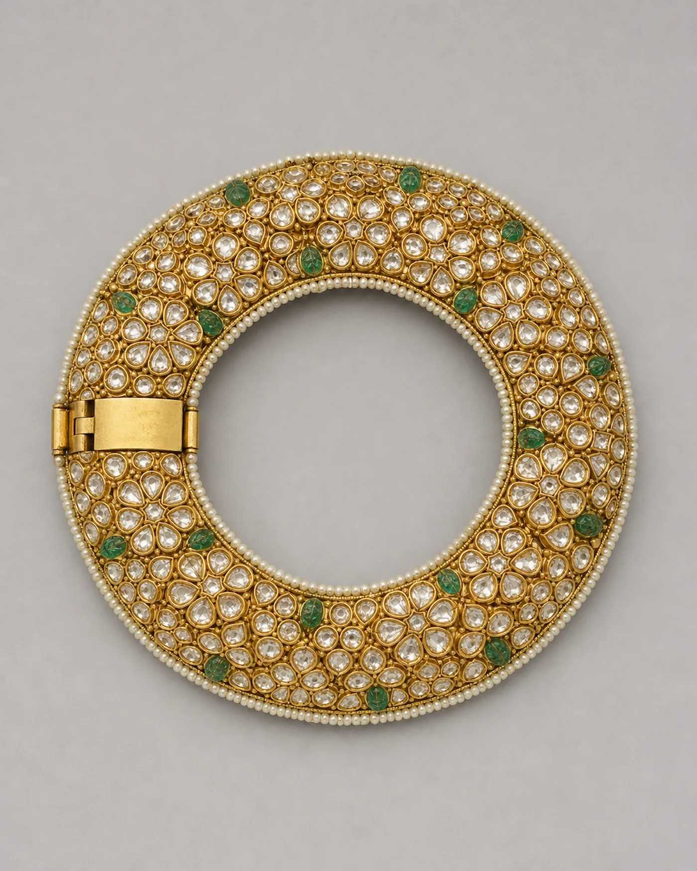 Wide bridal jadau kangan of polki flowerheads bedded in gold, rimmed in seed pearls with carved emerald beads