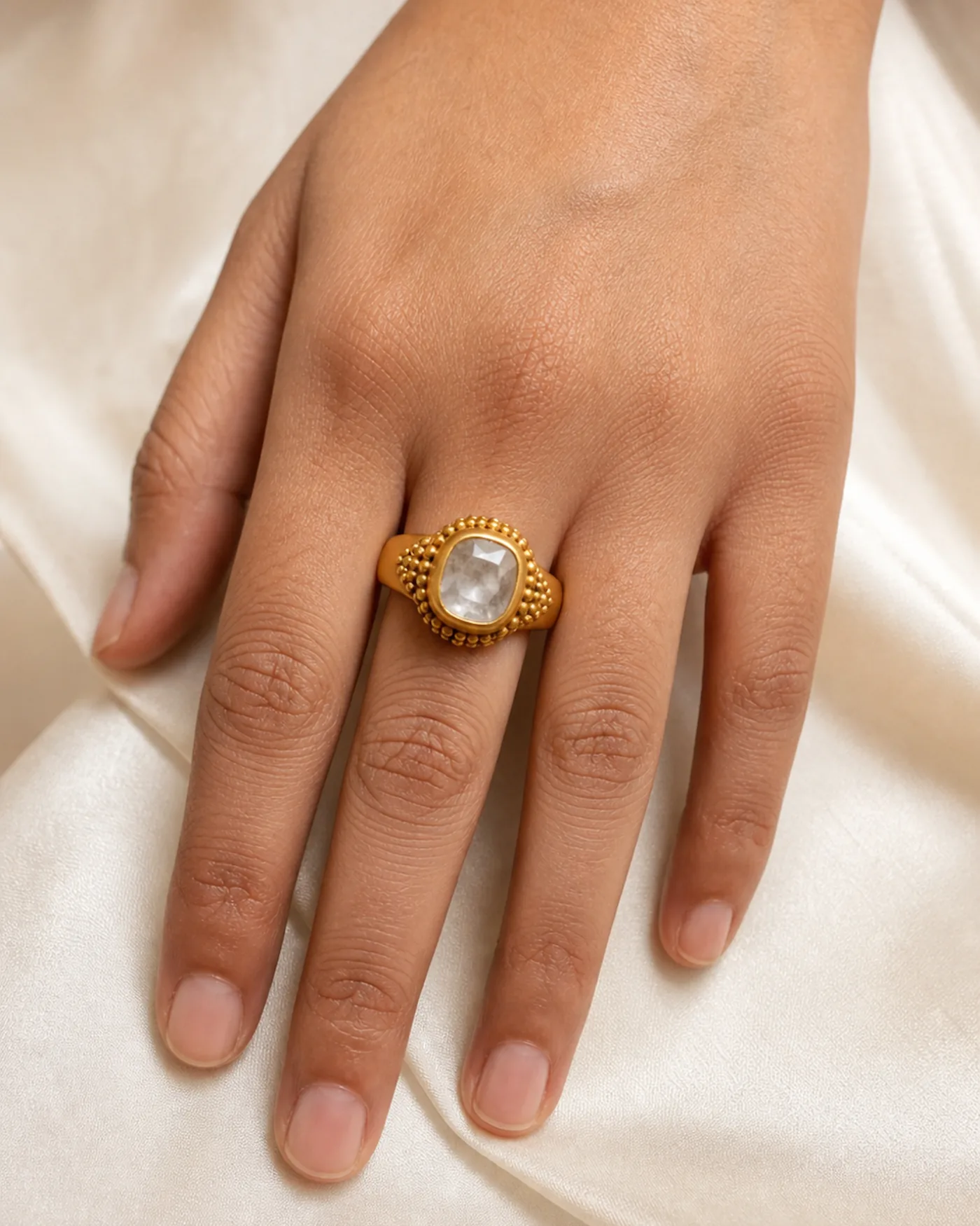 The ring worn on a hand, showing how small the band and its single stone are
